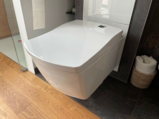TOTO NEOREST AC shower toilet combined with a white glass TECE lux panel and touch controls